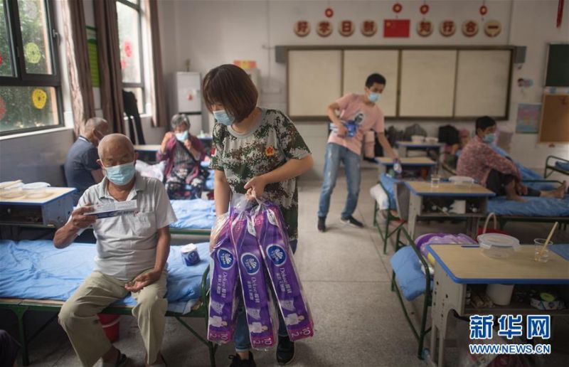 7月7日，在街道口小学东方雅园分校安置点，工作人员为武汉市洪山区天兴乡村民发放生活物资。 新华社记者 肖艺九 摄