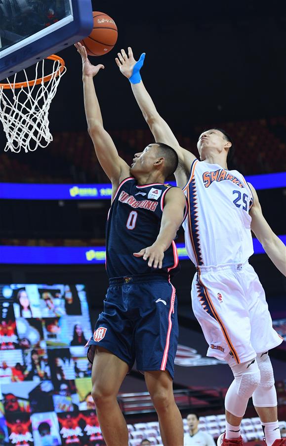 7月10日，广东东莞银行队球员刘权标（左）在比赛中投篮。 当日，在山东青岛举行的2019-2020赛季中国男子篮球职业联赛（CBA）复赛第二阶段（红岛赛区）比赛中，广东东莞银行队以122比89战胜上海久事队。 新华社记者朱峥摄