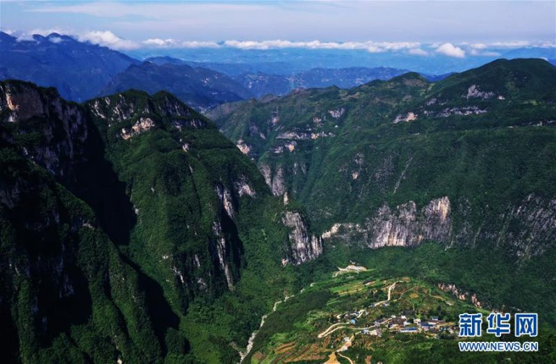 7月3日拍摄的下庄村（无人机照片）。 地处秦巴山区腹地的重庆市巫山县竹贤乡下庄村被称作“天坑村”。多年来，全村人凭借“不等不靠，幸福要自己造”的精神，走出了自己的一条幸福路。 曾经，四面绝壁犹如一圈难以跨越的高墙，将下庄人紧紧困在里面。闭塞的交通束缚了人们挣脱贫困和封闭的双手，阻挡着全村通向文明和富裕的脚步。不甘心“坐井观天”的下庄人，用生命挑战悬崖，村民拿着铁钎和铁锤，在悬崖上凿出一条“通天路”，彻底改变了村庄的命运。当地政府先后对下庄村的道路进行了加宽、硬化加固，并加装了护栏。如今，从下庄出发到县城的时间缩短到一个半小时左右。 通路后，村里的面貌很快发生了变化。2015年，下庄村完成整村脱贫。如今，下庄村建立了果蔬种植合作社，巫山县在这里建立了下庄精神陈列馆，建成了风貌统一的乡村民宿，帮助下庄村发展生态文旅产业。曾经的“天坑村”靠着自强不息的精神，道路越走越宽。 新华社记者 王全超 摄