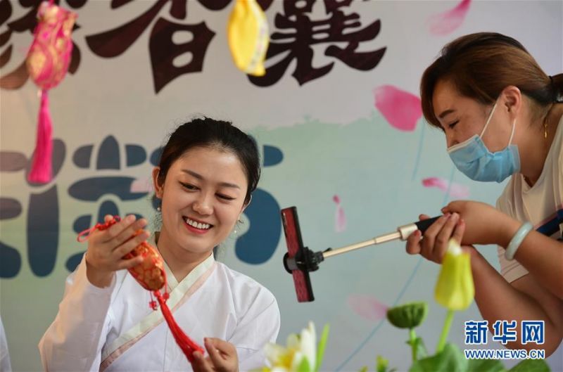 　6月24日，一名中医在河北省沧州市新华区志强路社区通过直播平台向观众介绍香囊制作方法。 端午佳节将至，各地群众举行了多种多样的活动迎接这一传统节日。 新华社发（傅新春 摄）