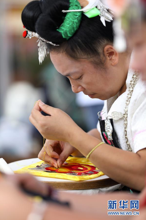 7月3日，在贵州省丹寨县万达小镇景区，苗族妇女在参加刺绣技艺比赛。 当日，贵州省黔东南苗族侗族自治州丹寨县万达小镇景区举办非遗手工技艺比赛，来自各村寨的苗族妇女共聚一堂，参加苗族刺绣、苗族蜡染绘画比赛，以比赛的形式促进非物质文化遗产的传承，吸引了在当地旅游的游客到场欣赏。 新华社发（黄晓海 摄）