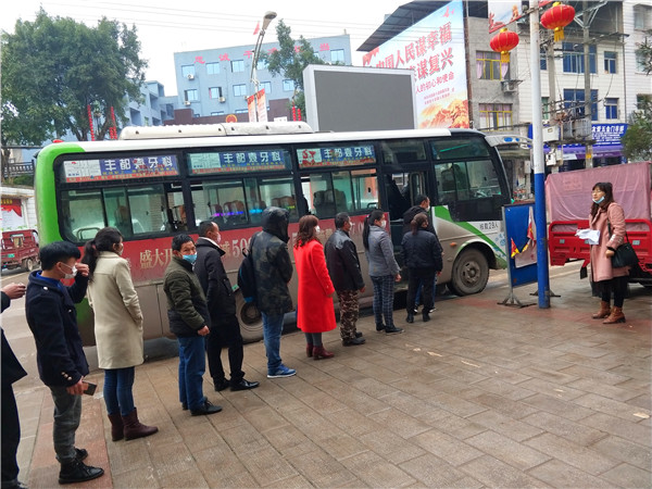 图2为：工作人员组织外出务工人员依次上车
