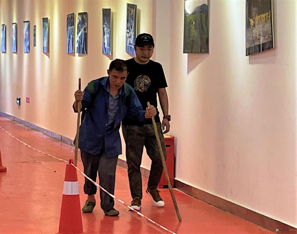 陈小丁搀扶着周胜培前往接种疫苗。