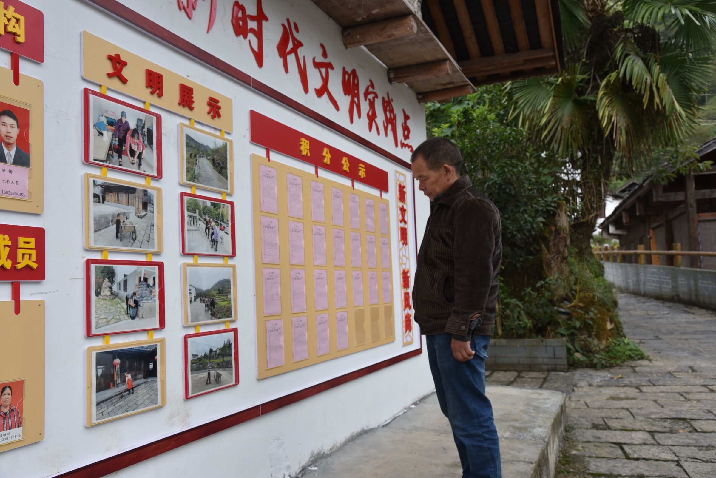 图为桃花源街道天山堡村村民吴靖徳正在观看自己的积分。