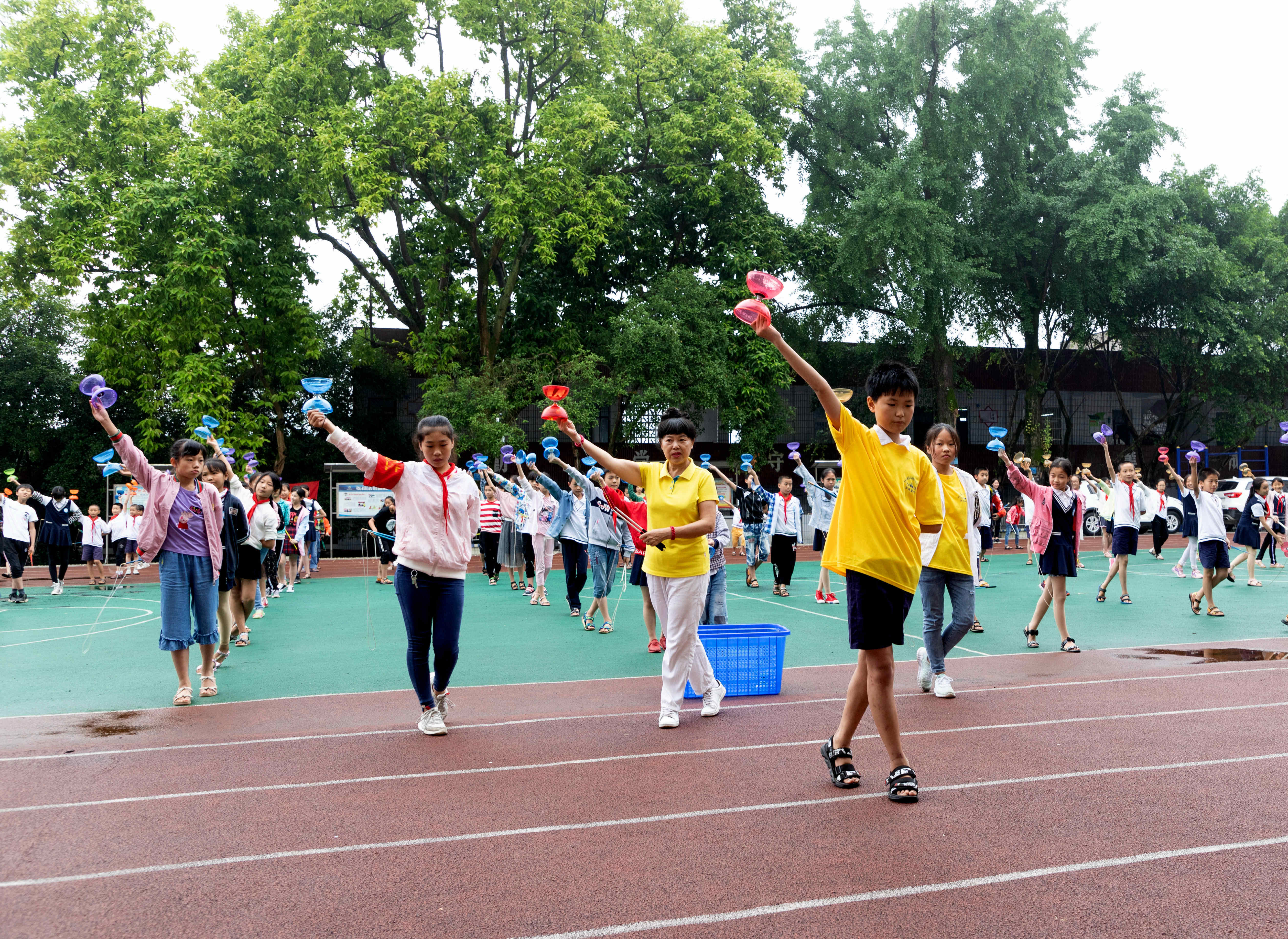 万州区小周中心小学的学生在非遗传承课上学习空竹.