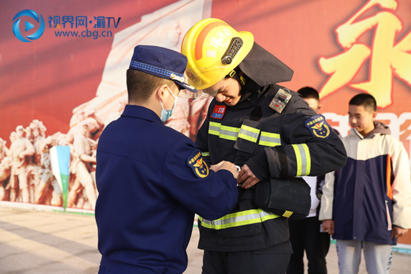 参与体验学生在消防警官的帮助下进行消防服穿戴体验。  杨雪 摄.jpg