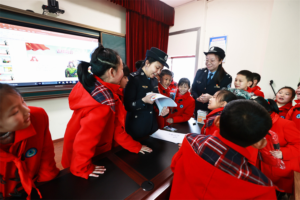 3月4日，龙桥街道中心小学校的学生与民警一起分享自己的&ldquo;我心中的雷锋&rdquo;绘画作品。.jpg