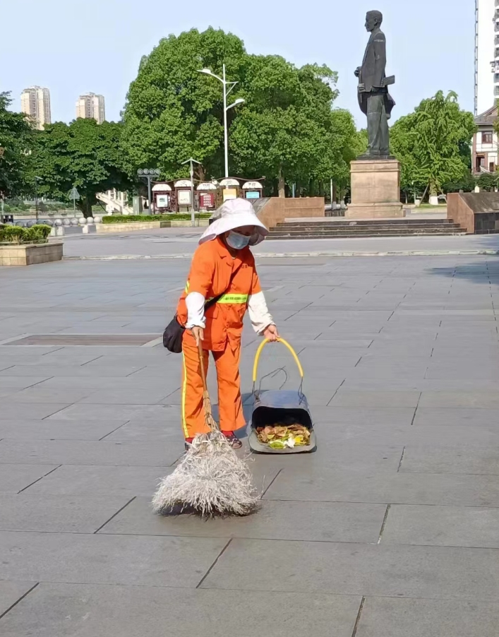 环卫工人刘光兰正在擦拭电线杆一把扫帚,拂过犄角旮旯,满身汗水,洗净