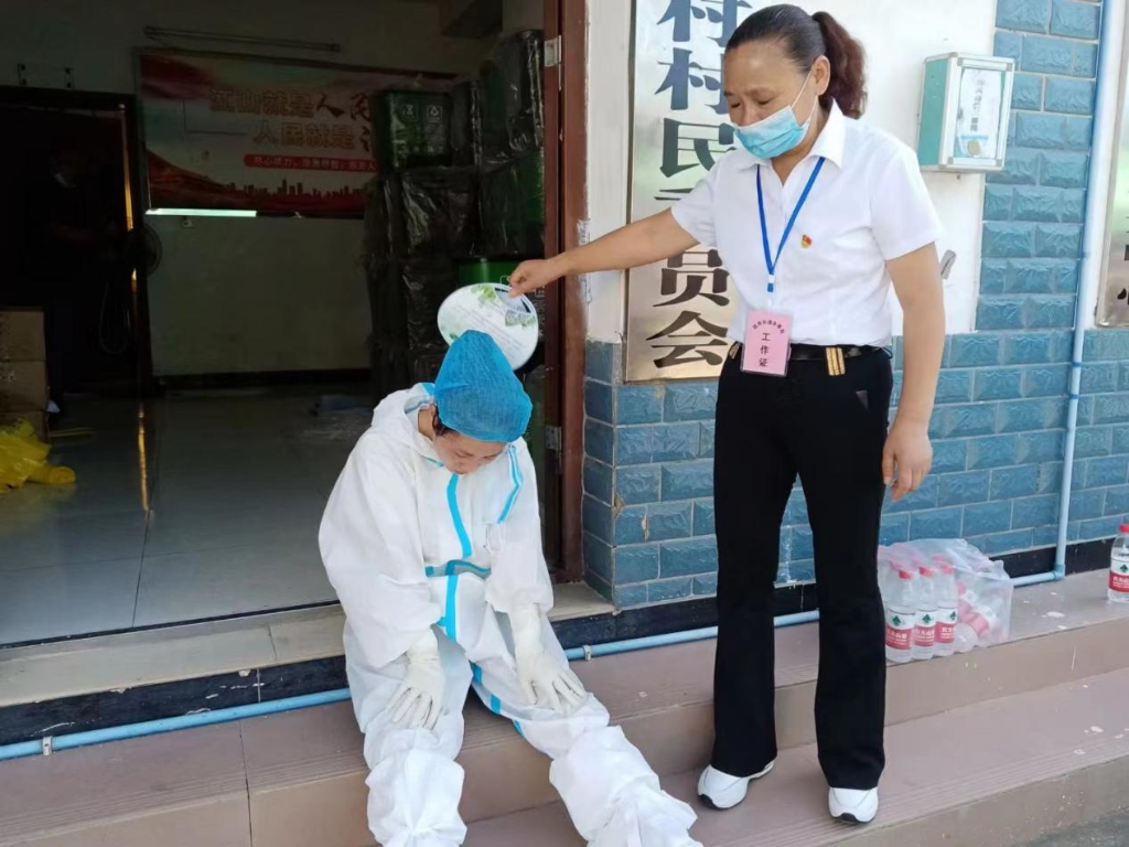 高温难耐，合川区核酸采样点志愿者为采样人员扇风降温。重庆市卫健委供图
