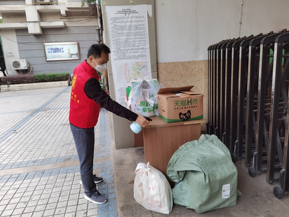 沙坪坝新鸣社区，马金超在门岗值守，对快递进行消毒。重庆市人民防空办公室供图  华龙网发