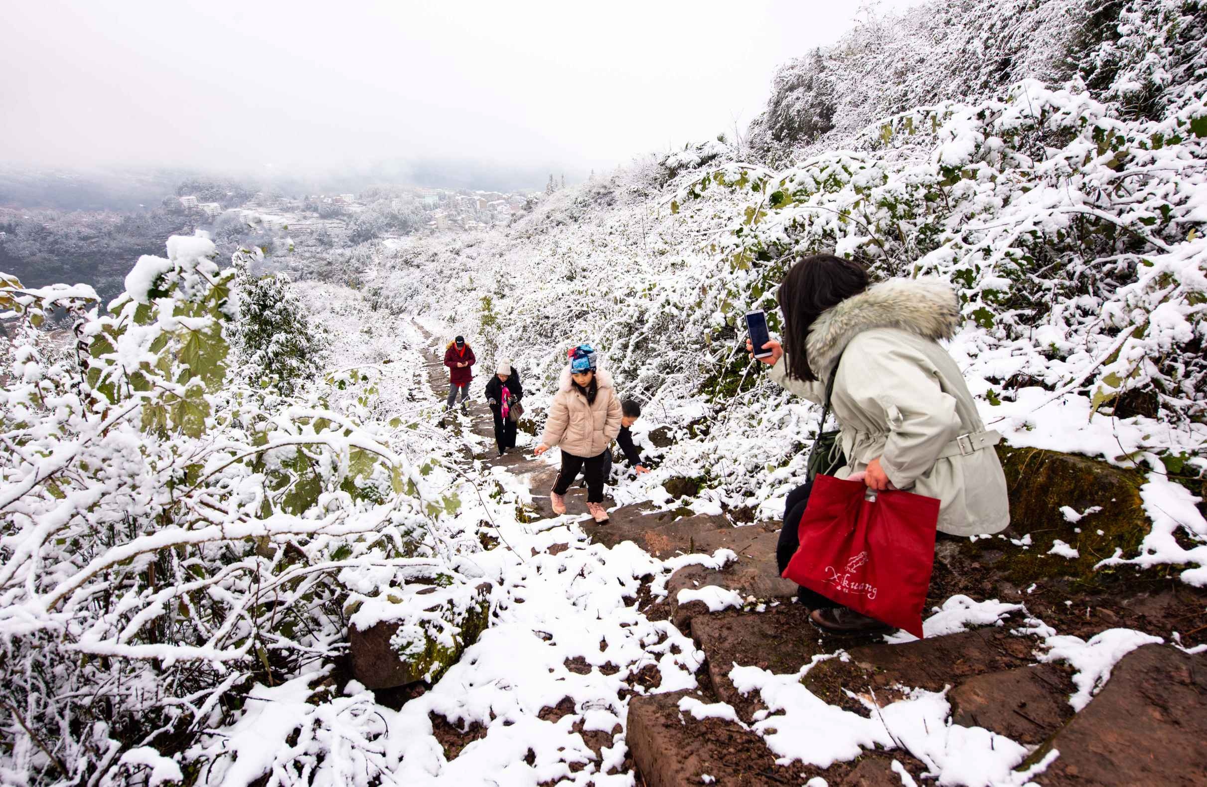 游人在郭扶镇狮子山观赏雪景。（摄影：肖七妹）