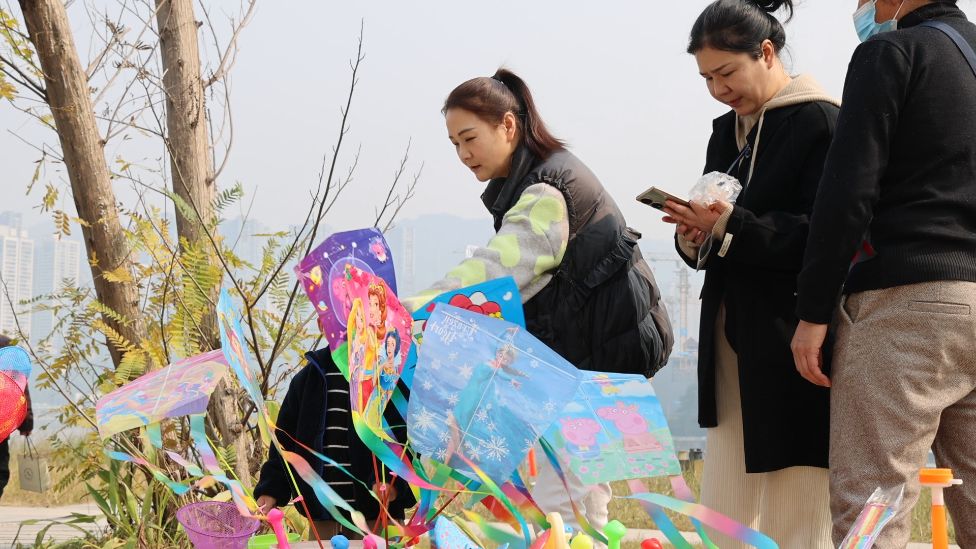 公园游客为孩子购买风筝。汪晶晶摄