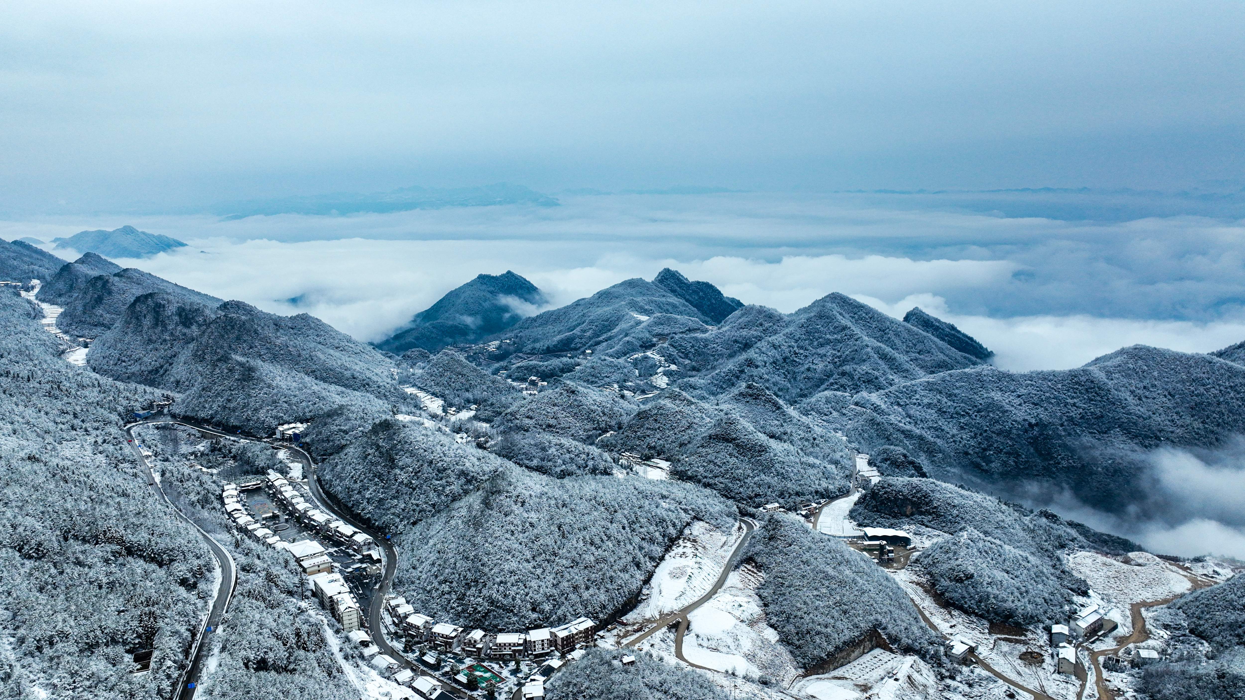 从空中俯瞰，雪花漫天卷地，勾勒出一幅别具特色的春雪胜景图。（摄影：谭启云）