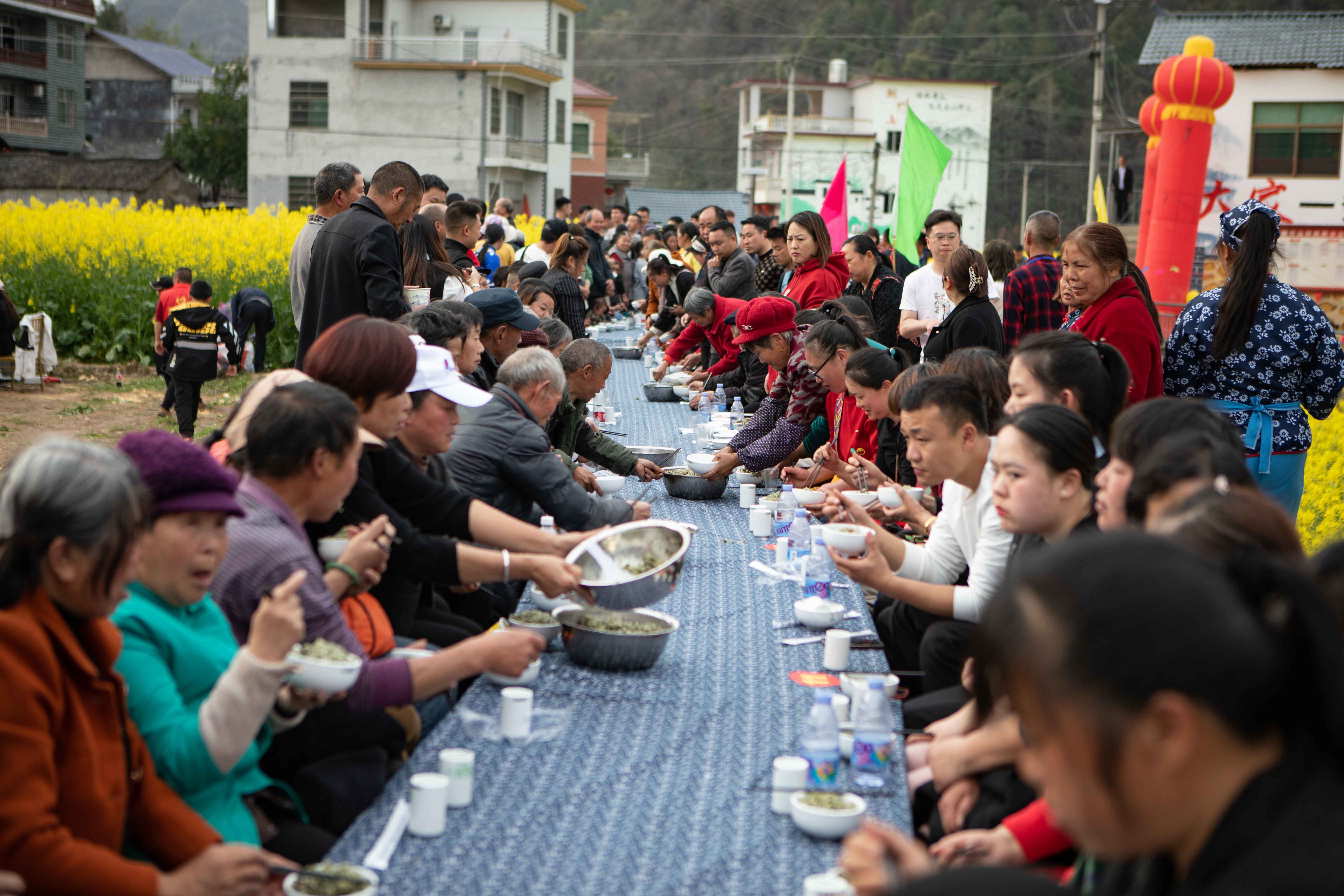 游客、村民品尝当地美食“社饭”。胡程 摄