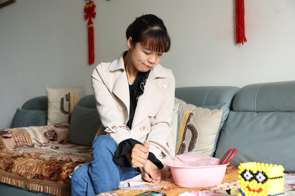 李红梅正在制作手工挎包。（李晨 摄）