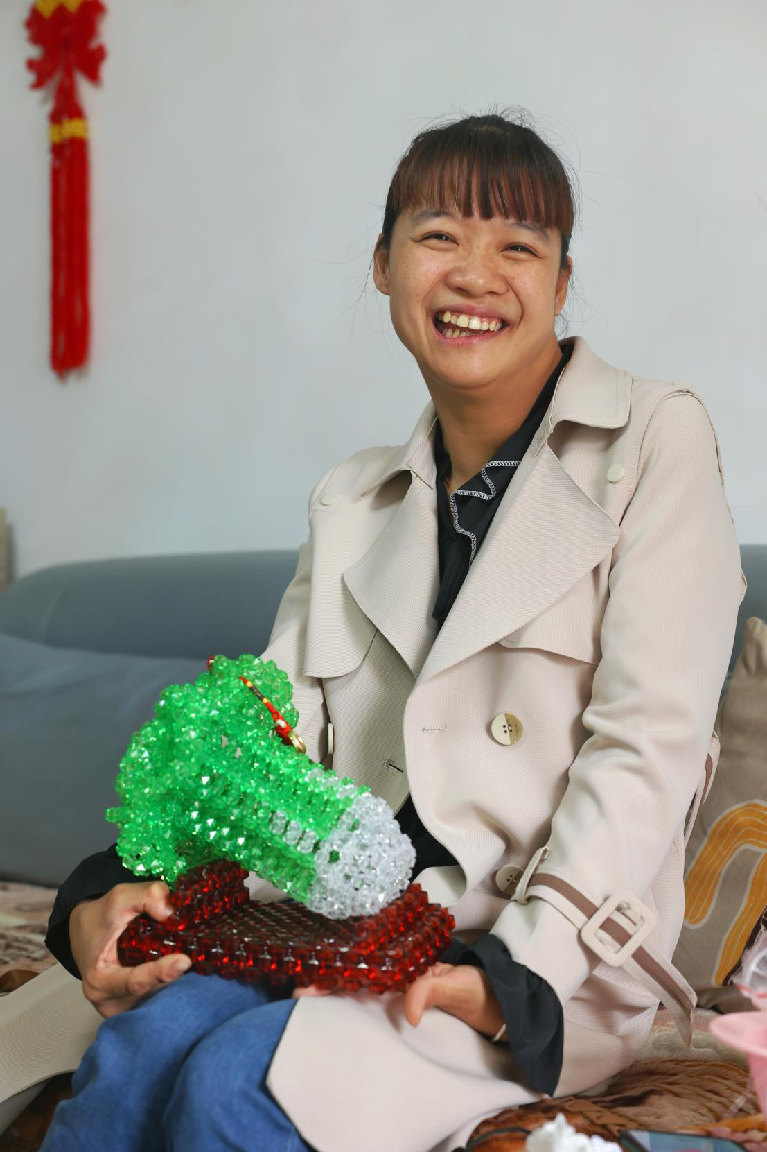 李红梅与她的作品“百财如意”。（李晨 摄）