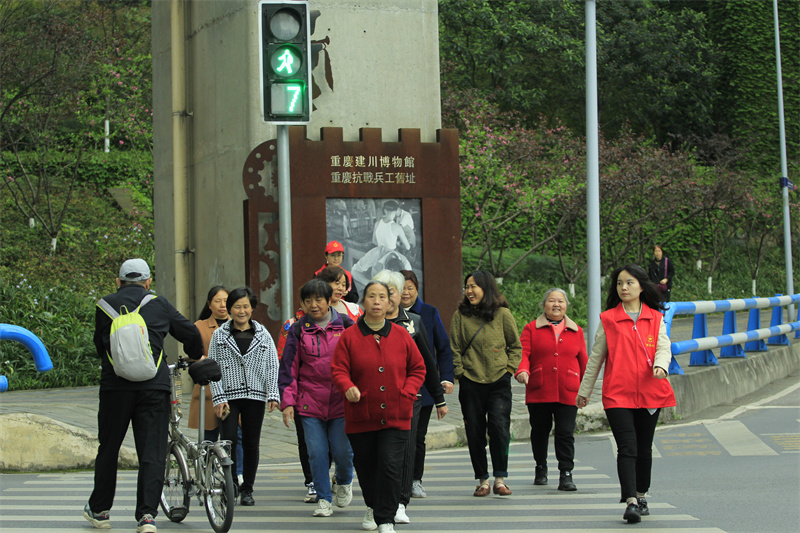 文明网格员在路口劝导行人遵守交通规则。（谢家湾街道供图）