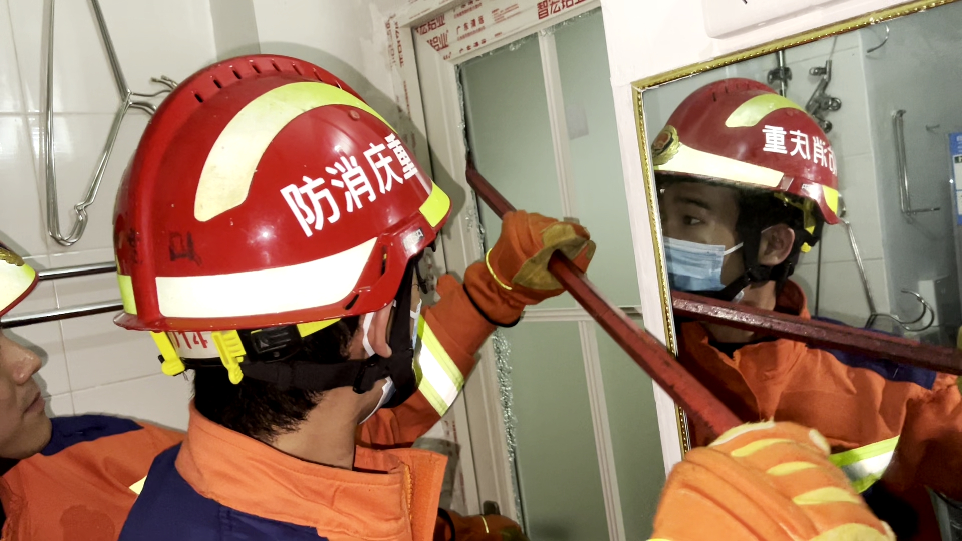 消防救援人员逐层击碎卫生间门上的玻璃（大渡口区消防救援支队供图）_副本.jpg