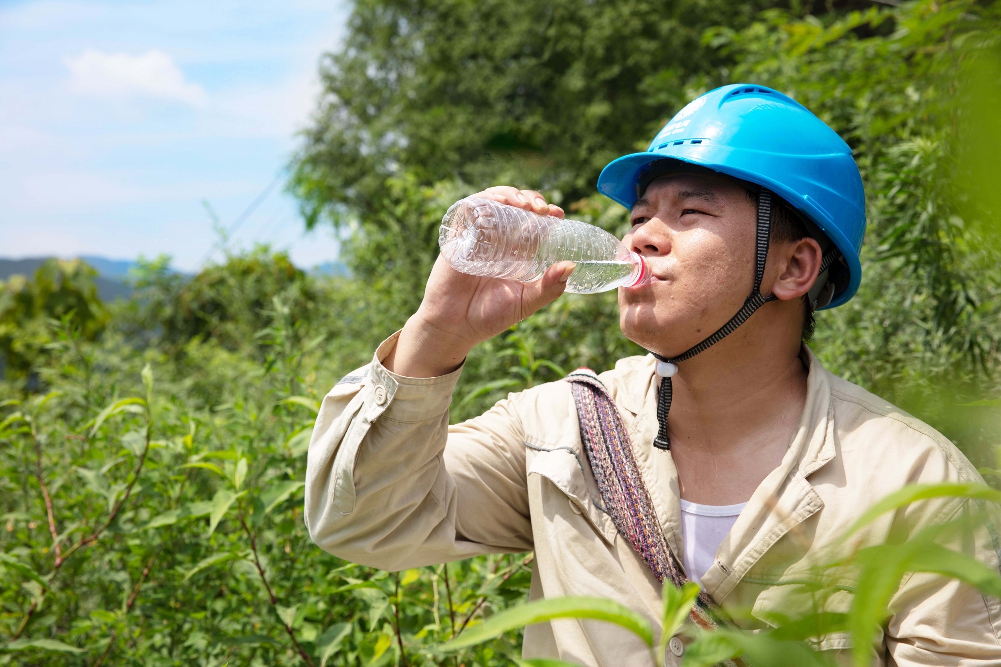 7月17日，國網(wǎng)重慶開州供電公司電力員工在烈日下進行巡線工作，保障電網(wǎng)的安全運行。譚友林 攝