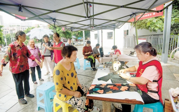 白鹤社区志愿服务集市，志愿者正在开展便民服务。九龙坡区融媒体中心供图