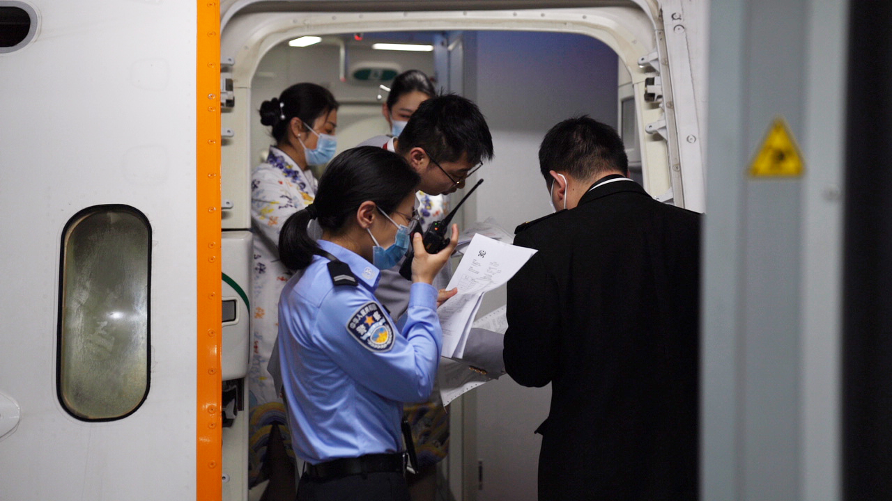 重庆边检民警在登机口与机组成员核对航班资料.JPG
