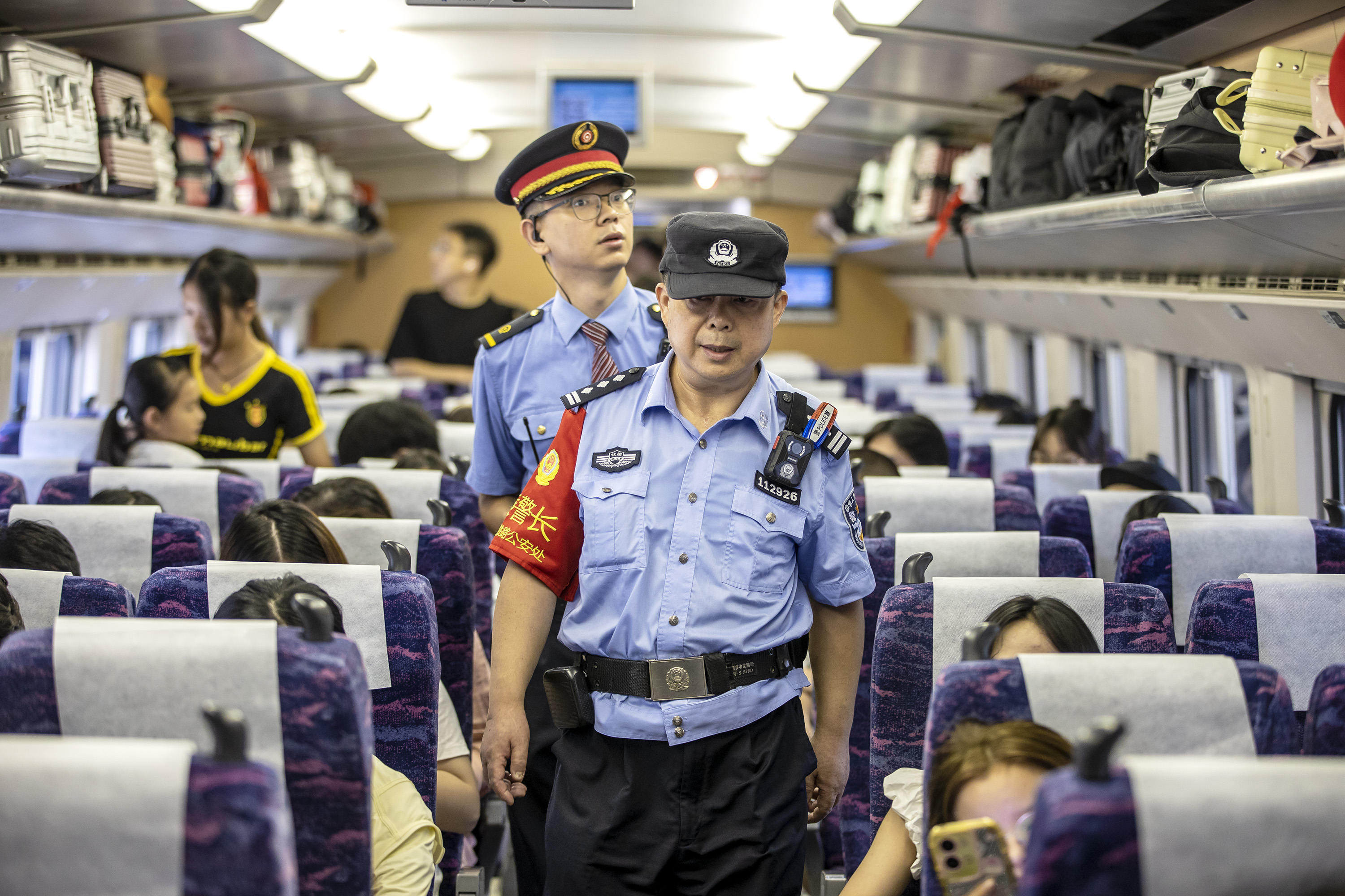 圖為列車乘警和列車長在車廂開展巡邏防控。胡勇 攝.jpg