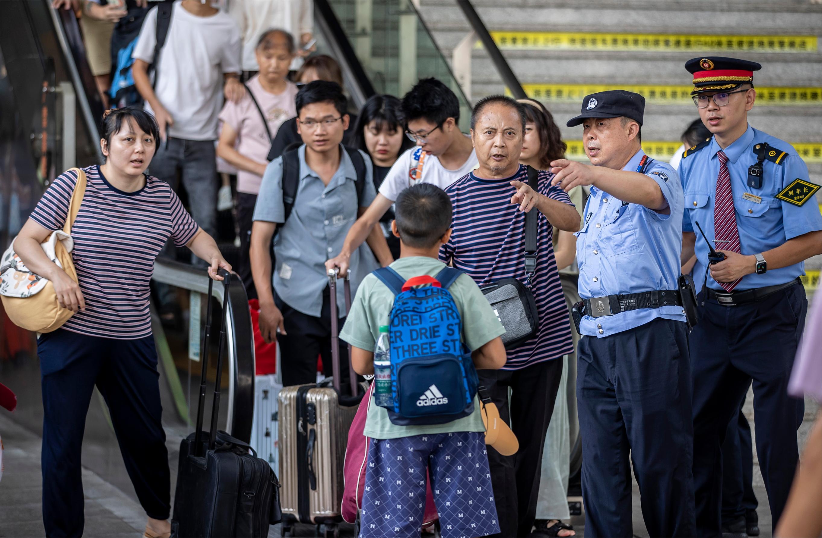 圖為列車警長和列車長在站臺引導(dǎo)旅客有序上車。胡勇  攝.jpg