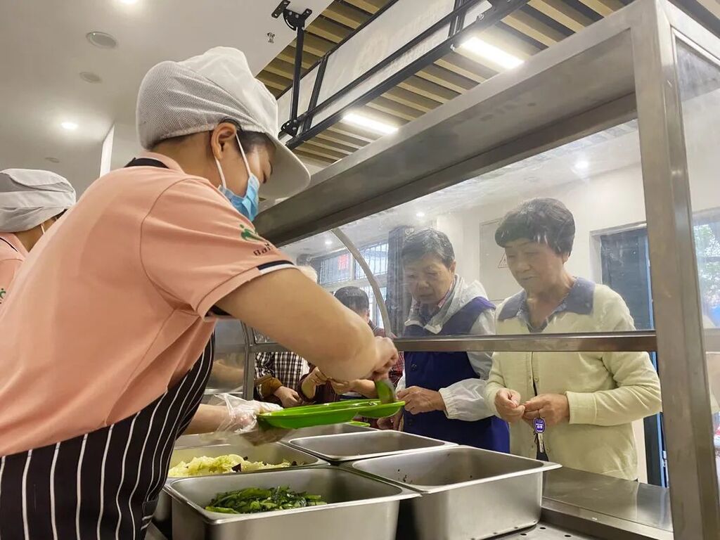 老人们老人正在南岸区团圆堡社区食堂打饭。