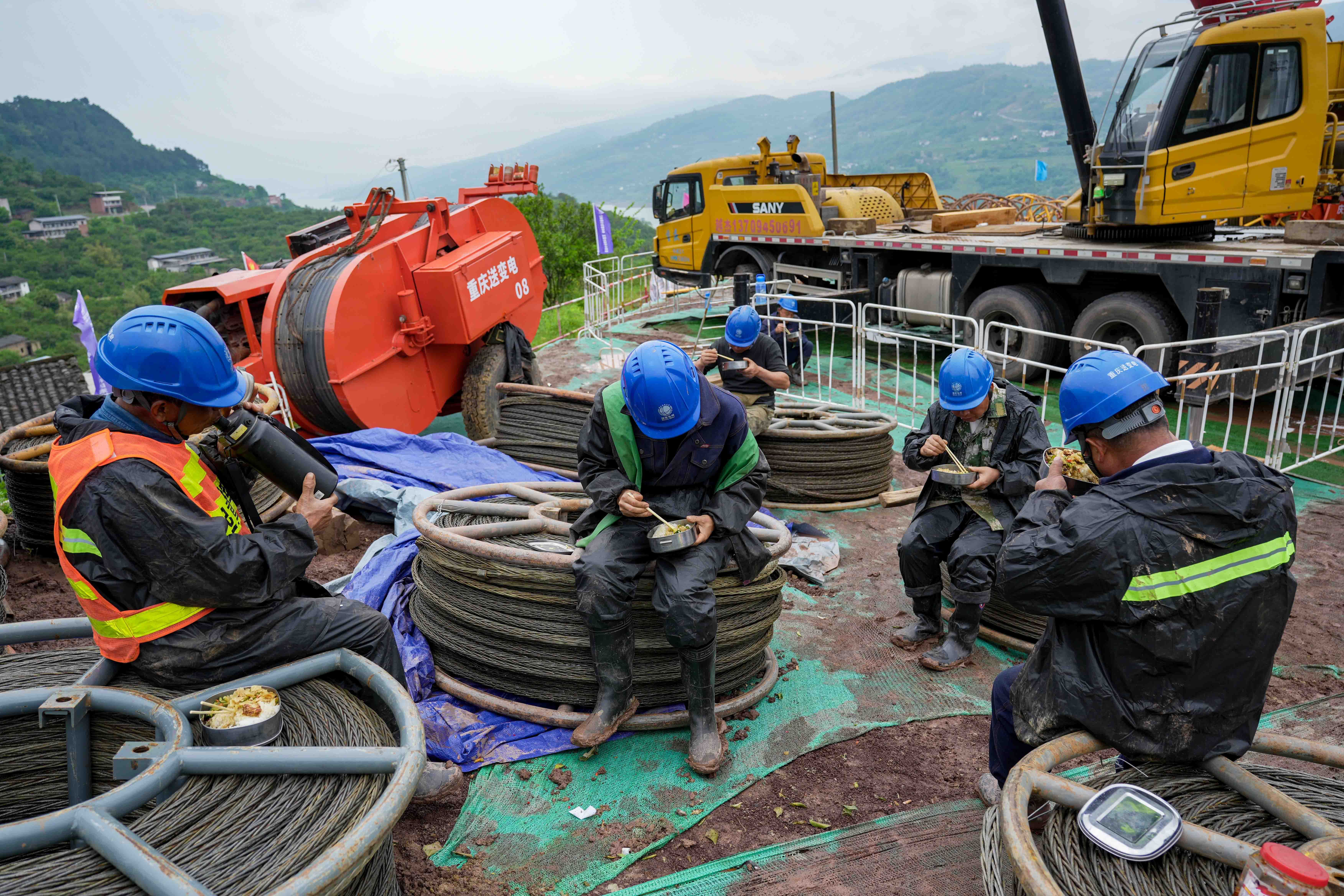 工人为抢工期就地吃午餐。黄建桦 邓晓琴 摄