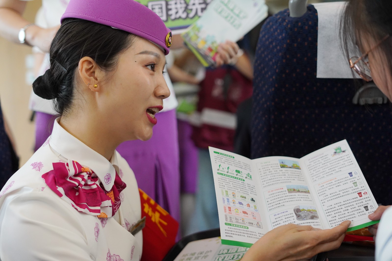 圖7：2025年6月24日，在重慶西開往西安北的G2234次列車上，志愿者為旅客講解宣傳手冊內(nèi)容。羅希雅 攝.jpg
