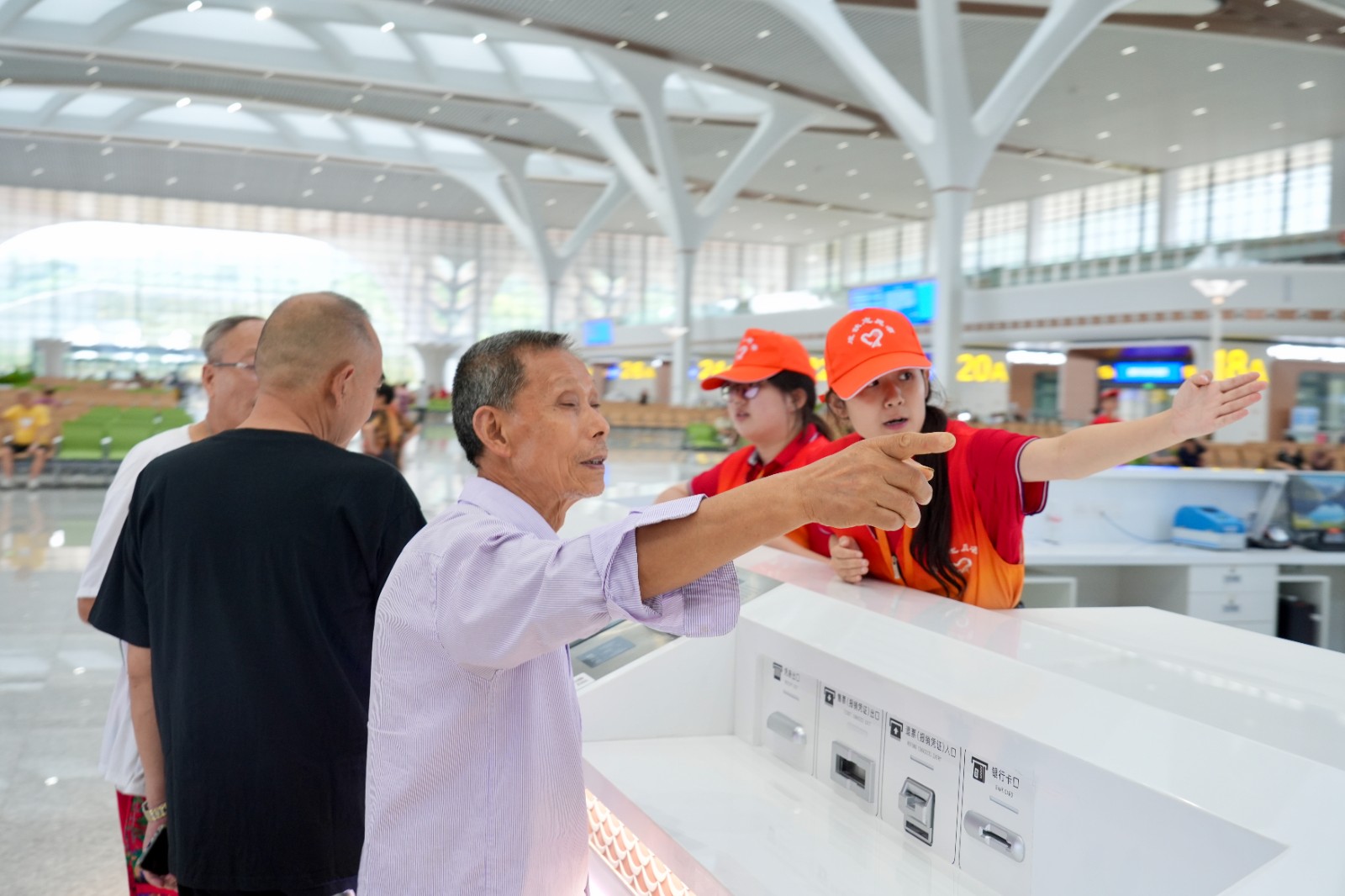 图示：重庆东站服务台志愿者解答旅客问询（魏伟  摄）.jpeg