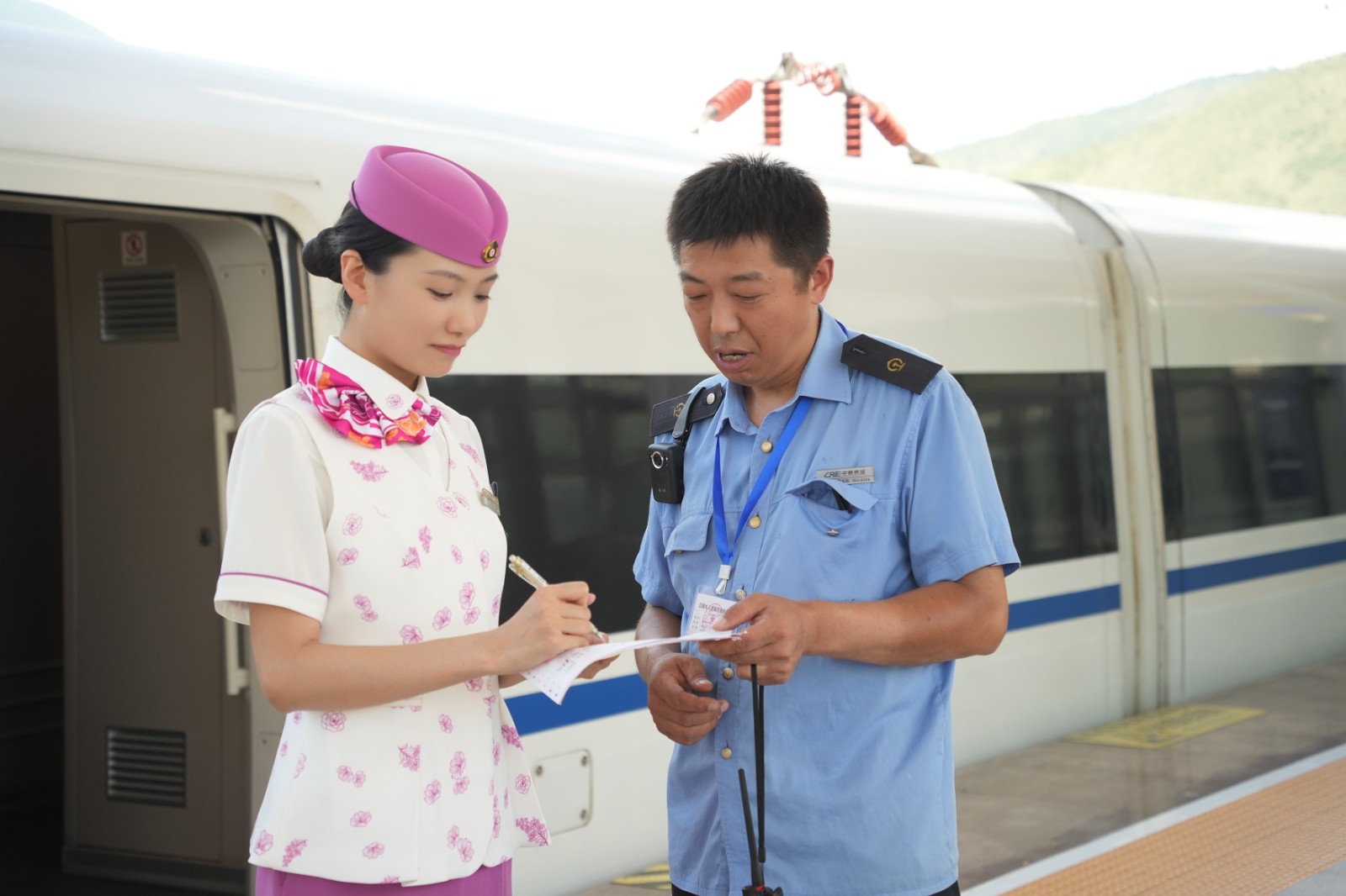 图为7月5日，S5527次列车长与中铁快运公司工作人员进行交接，谭志鹏摄.JPG