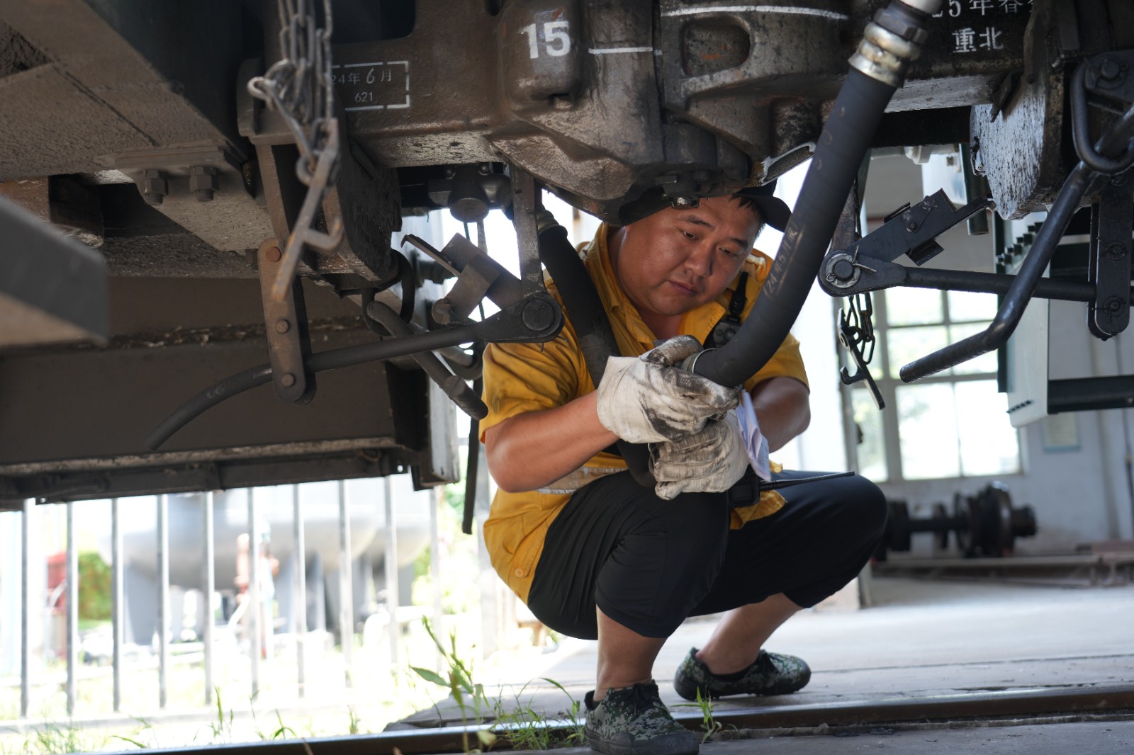 在重庆北站客车整备所内，连结员在在完成列车风管连接作业（魏伟 摄）.jpeg