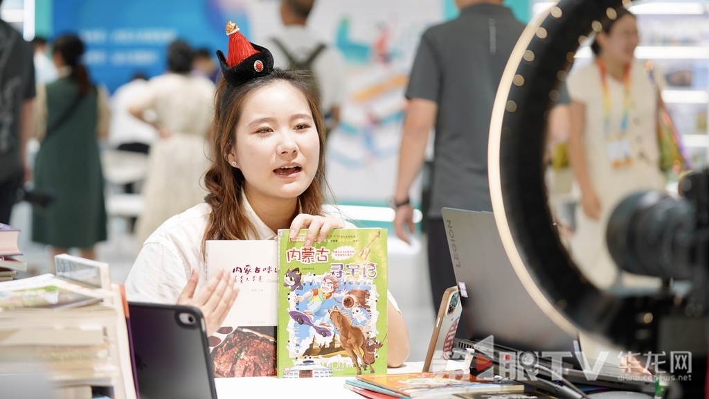 展台前,主播在线直播向读者推荐。 第1眼TV-华龙网记者 刘钊 摄