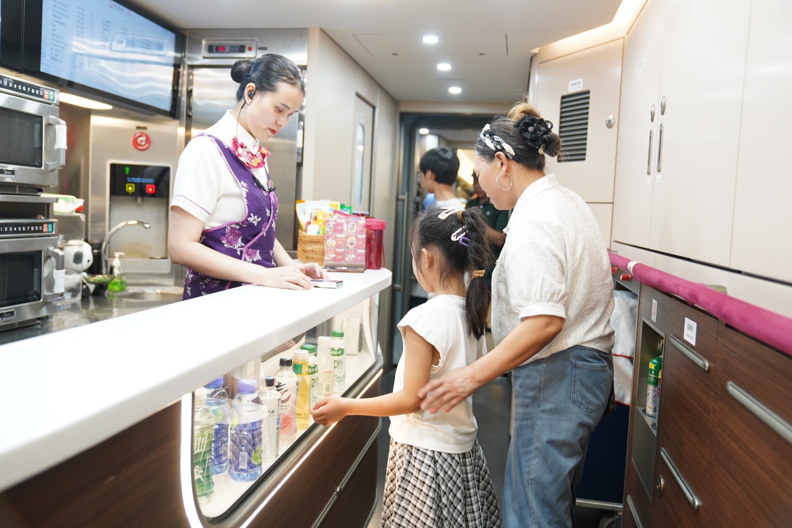 图为:重庆客运段在列车上进一步优化旅客服务工作,主动为旅客提供引导、答疑、应急防暑药品等温馨服务,并上新了更适合夏季的特色餐食。罗希雅 摄.jpg