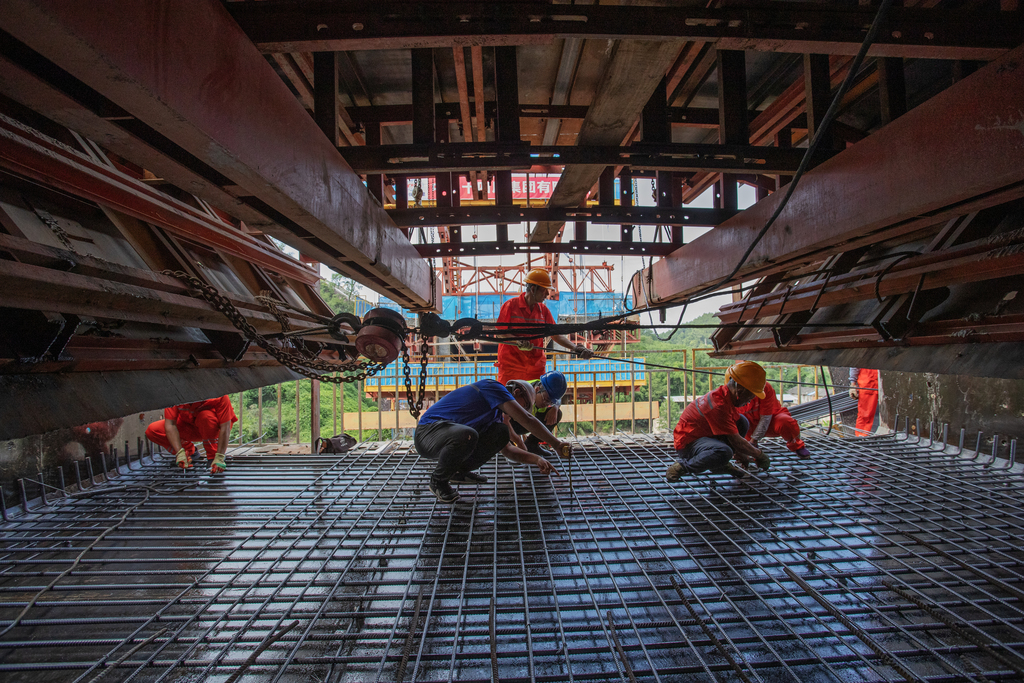 5、技术员路成刚（左二蓝）和工友们核对施工数据