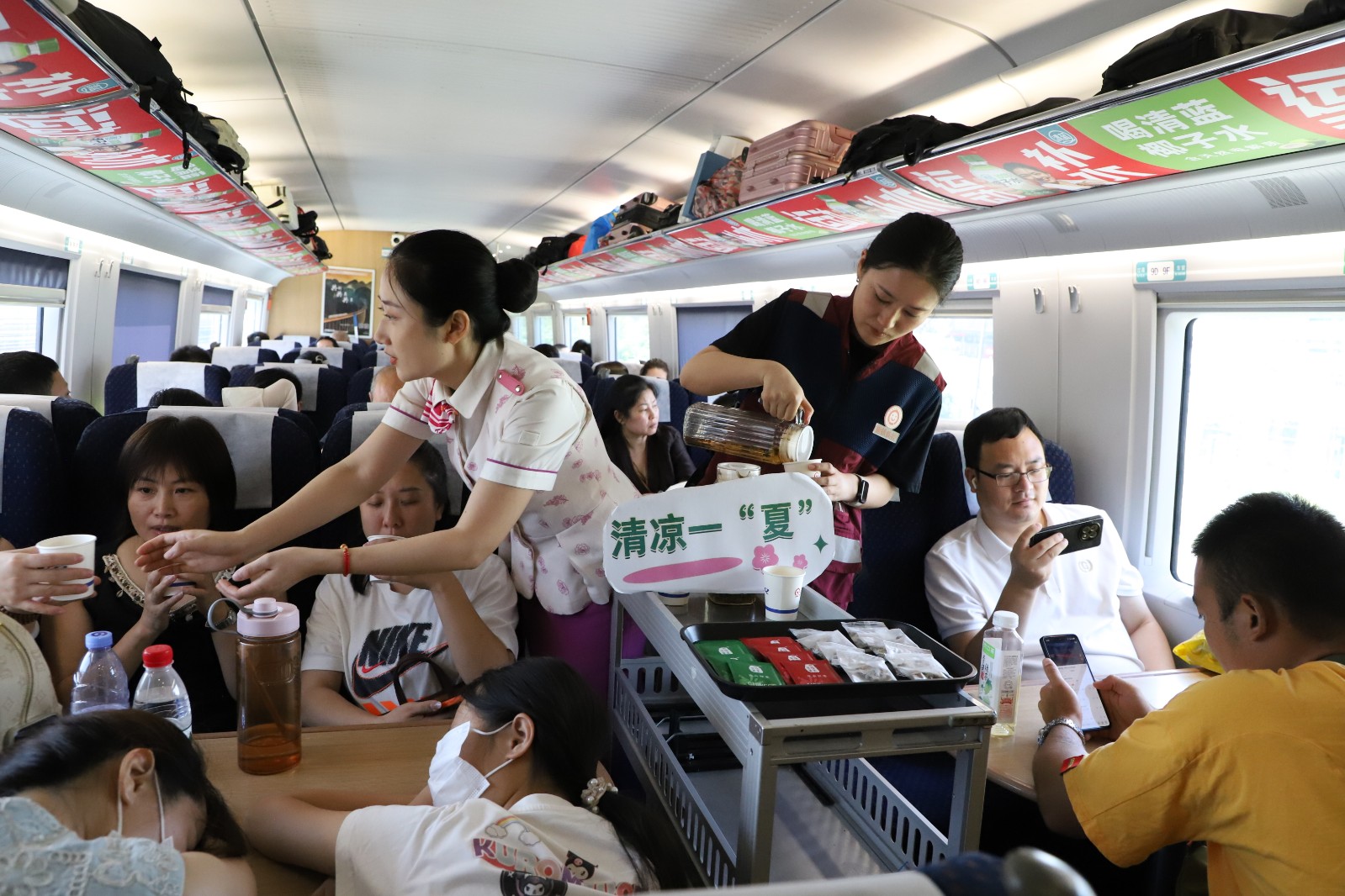 G2234次,乘务员与重庆铁路疾控所医师,为旅客送上凉茶。何月摄.jpg