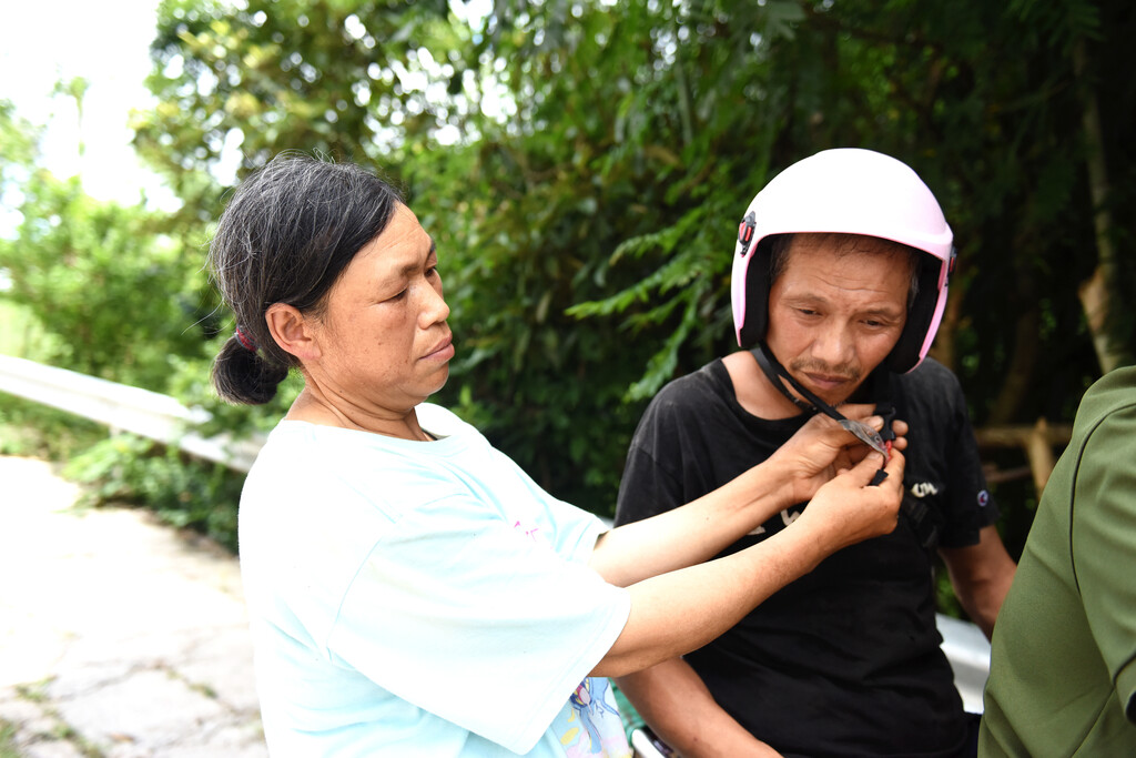 王洪秀(左)为坐摩托车的小叔子向维安系安全带