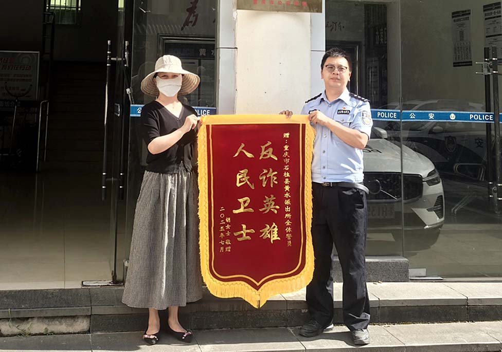 胡女士(左)向黄水派出所民警赠锦旗