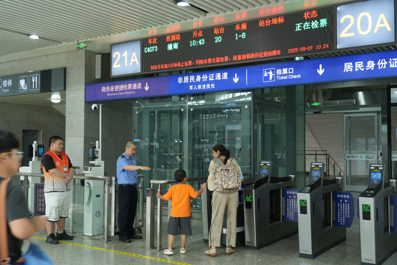 重庆北站工作人员引导小朋友旅客走人工检票口乘车（魏伟 摄）.JPG