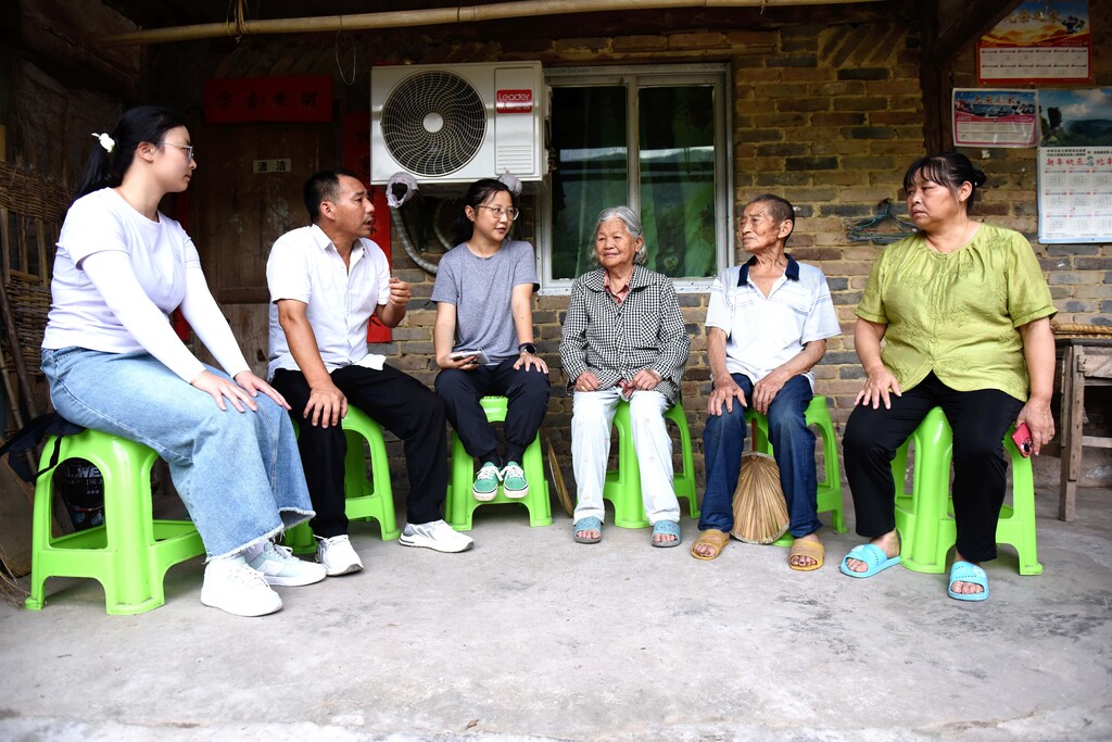 镇村干部走访问谭文宜(右二)及家人