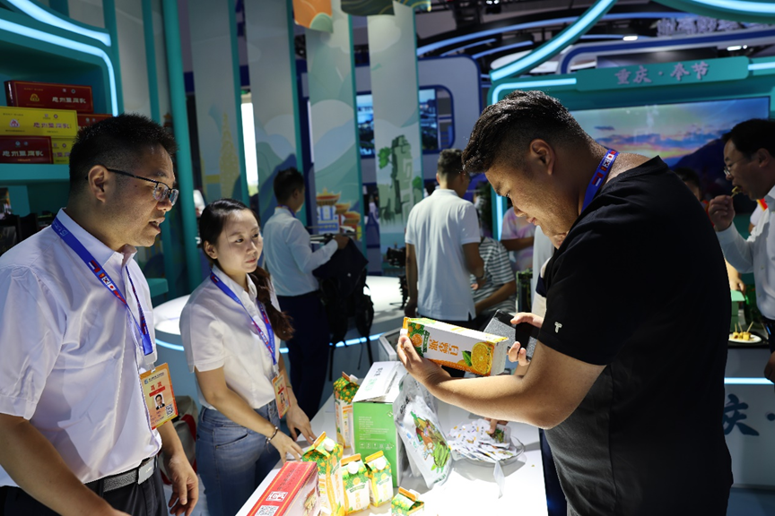 消费者和采购商驻足品鉴、咨询&ldquo;忠州佳品&rdquo;。拍摄：邓勇3.png