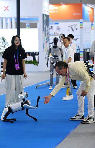 ▲9月4日,重庆国际博览中心,智能机器人展区,媒体记者和机器狗_握手”。 龙帆 摄.jpg