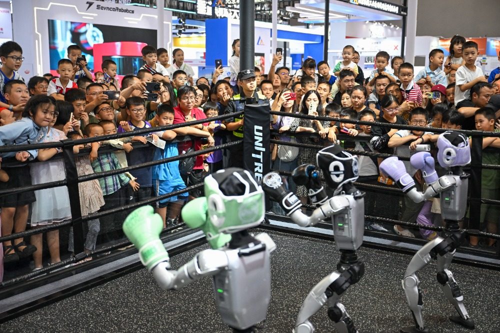 ▲9月6日,重庆国际博览中心,参与格斗赛的机器人与观众互动。.jpeg