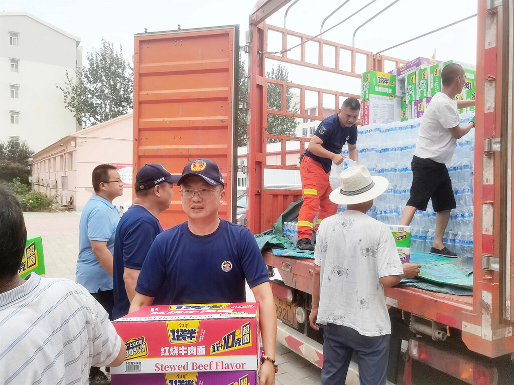 马宇锋(中)在搬运救援物资