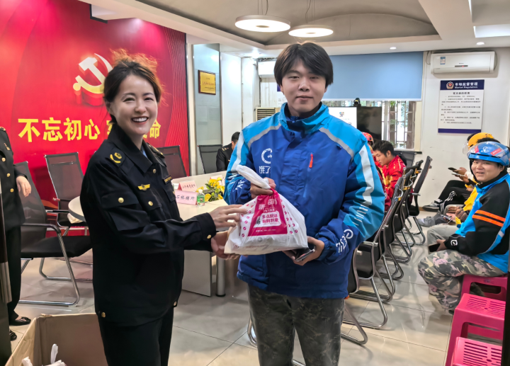 一 服务点工作人员为新业态劳动者送上暖心物品。区市场监管局供图.jpg