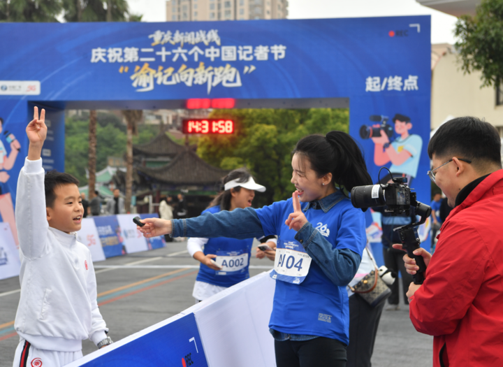 一 融媒体中心记者在“渝记向新跑”活动现场,采访参赛选手。 记者 周邦静 摄.jpeg