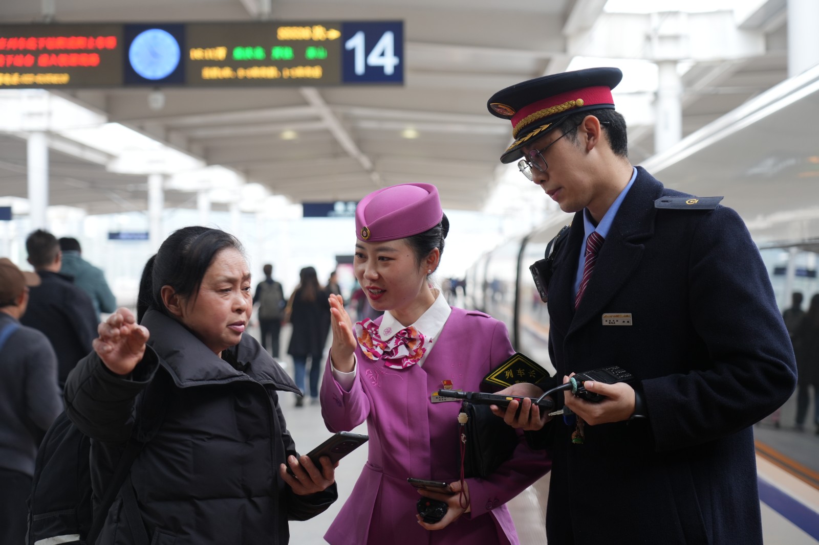 铁路工作人员在重庆北站站台引导旅客前往车厢（魏伟 摄）.JPG