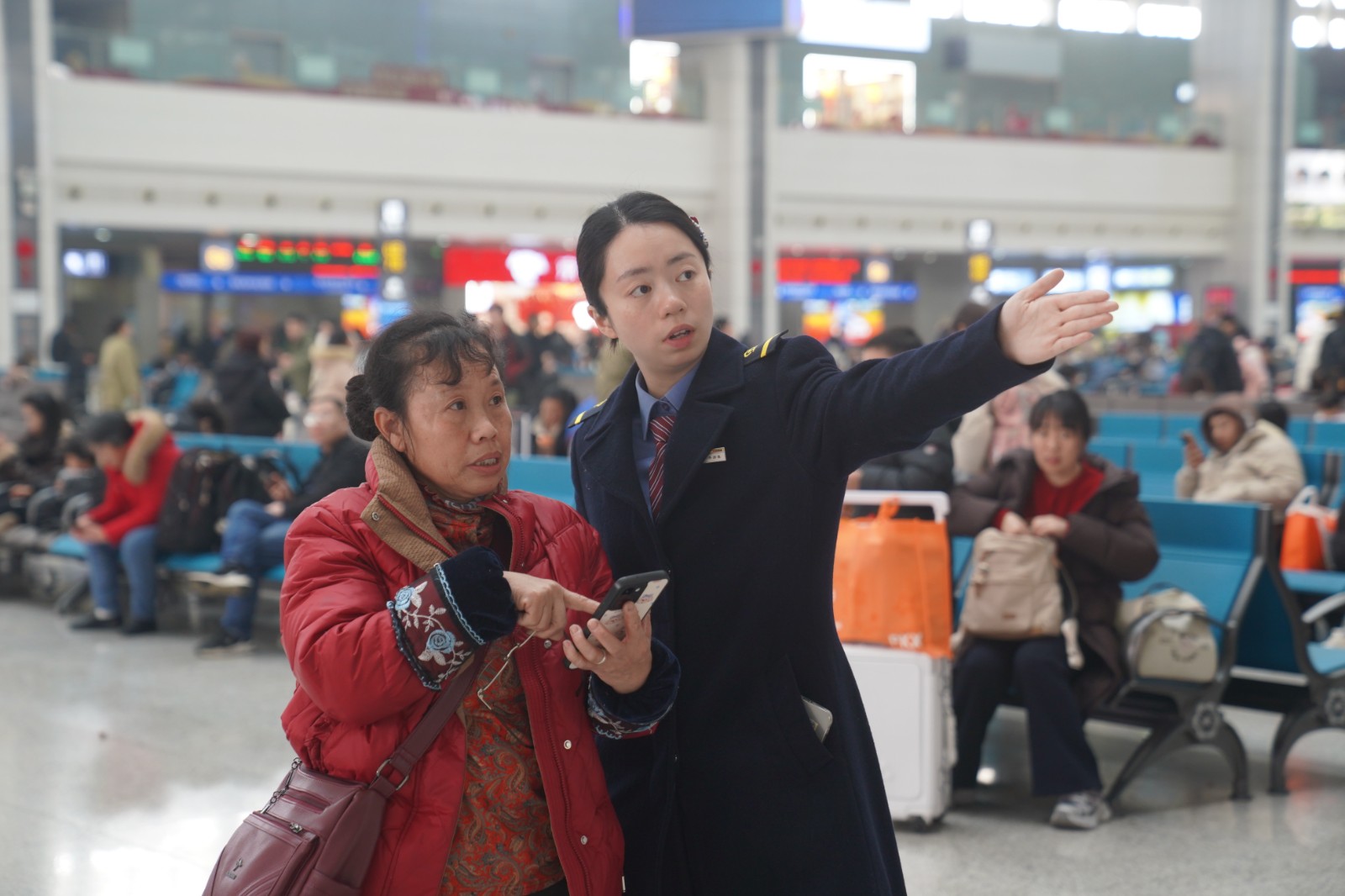 图示：车站工作人员为旅客指引检票口（汪亮 摄）.jpeg