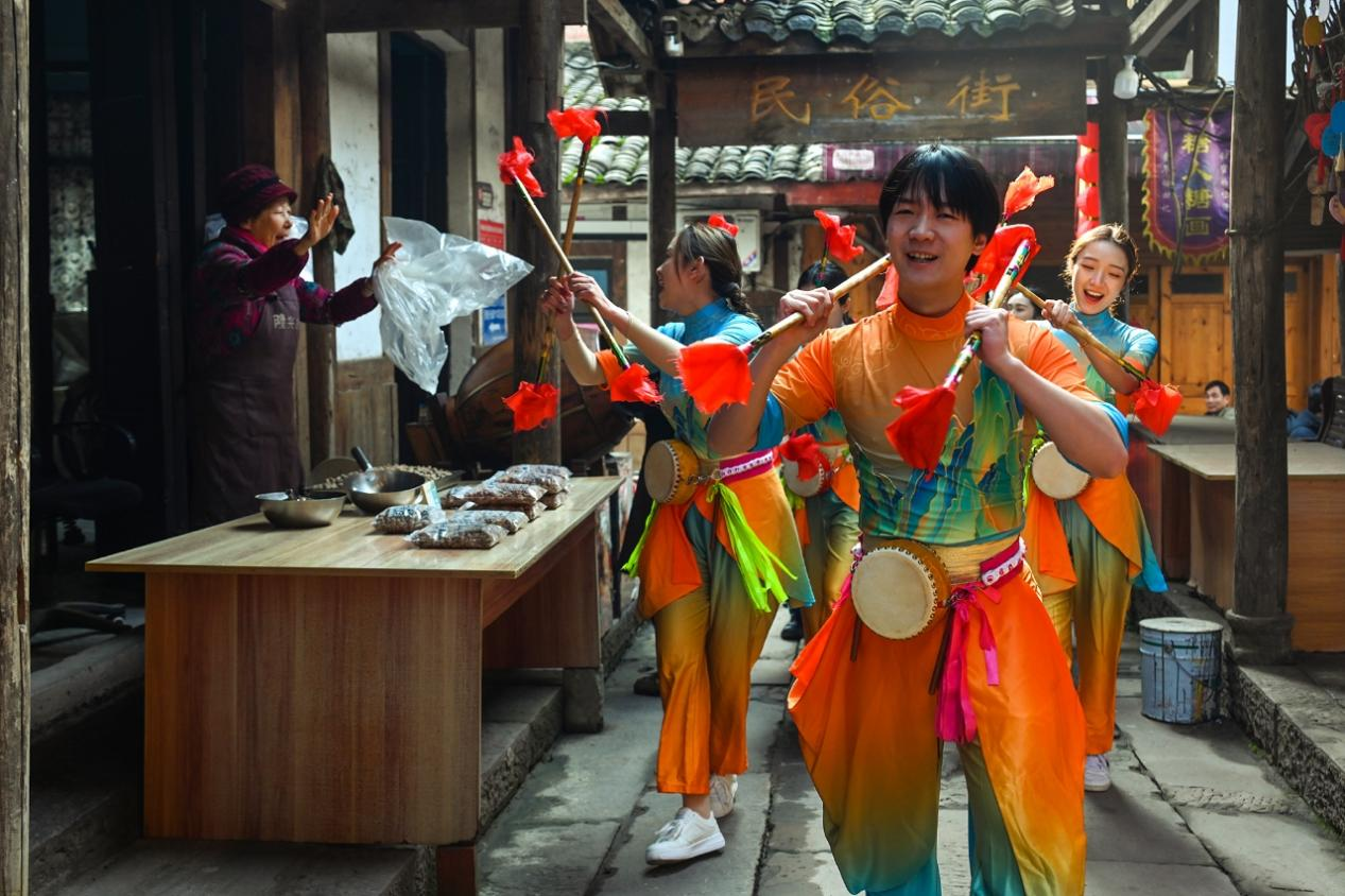 龙兴古镇，市民游客参与莲箫锣鼓巡游。汪彦彤 摄.png